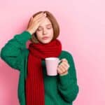 Photo-of-unhappy-upset-young-lady-wear-green-sweater-red-scarf-feeling-bad-drinking-hot-medicine-isolated-pink-color-background